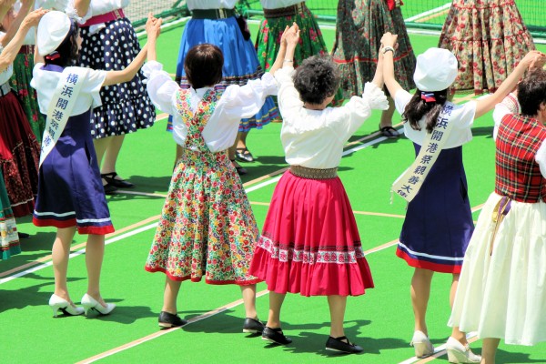 フォークダンス発表会でクラブの皆さんと一緒に踊る横浜開港祭親善大使の西村若奈さんと渡部結郁子さん（パシフィコ横浜円形プラザ）