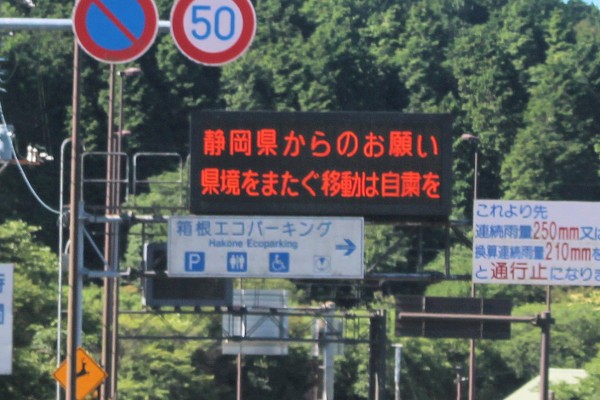 「県境をまたぐ移動は自粛を」と呼びかける静岡県の国道上の標示（箱根峠 静岡神奈川県境）